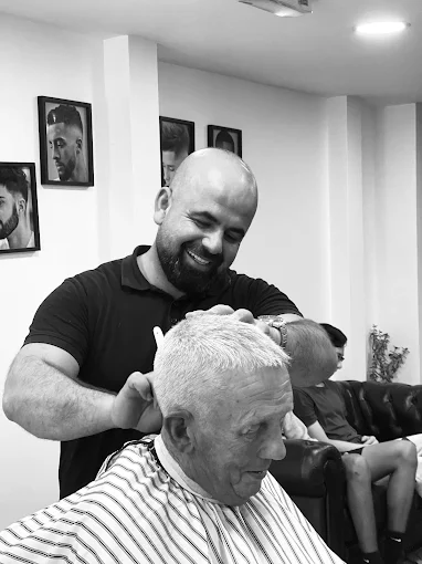 Lead barber Kardo cutting a long-time customer at Fade & Trim Barbers