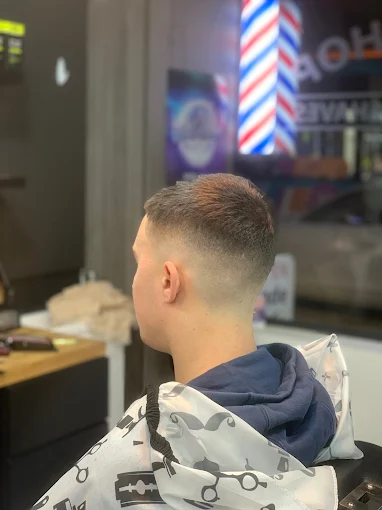 Fresh skin fade with the classic barber pole reflected behind